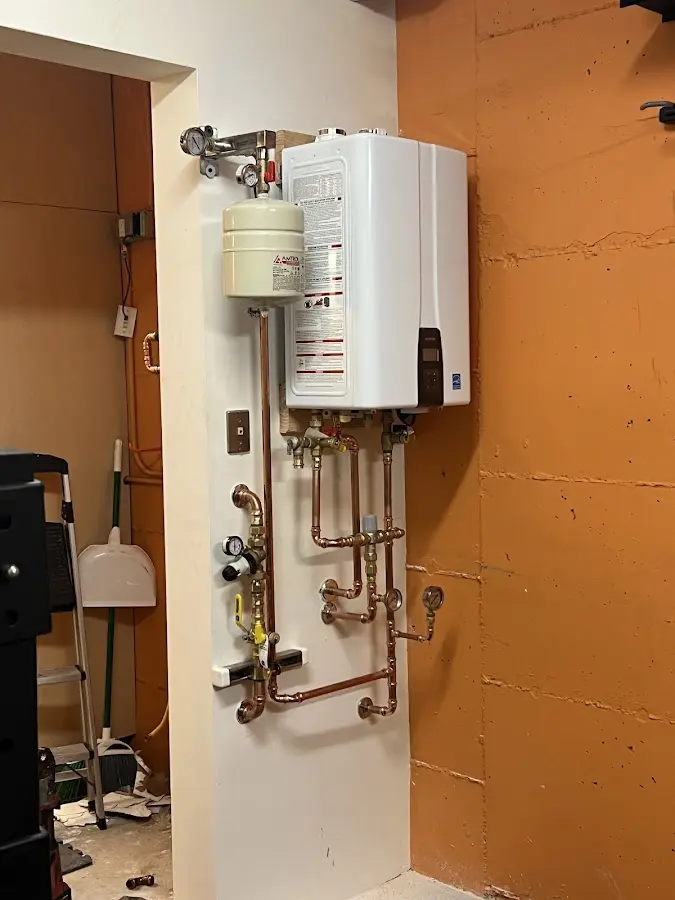 Plumbing technician inspecting water heater connections in Moses Lake
